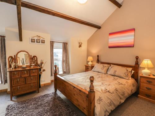 a bedroom with a wooden bed and a wooden dresser at 60 Hyfrydle Road in Caernarfon