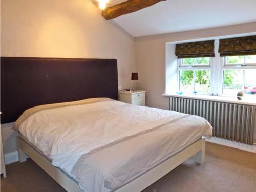 a bedroom with a large bed and a window at Rose Cottage in Grassington