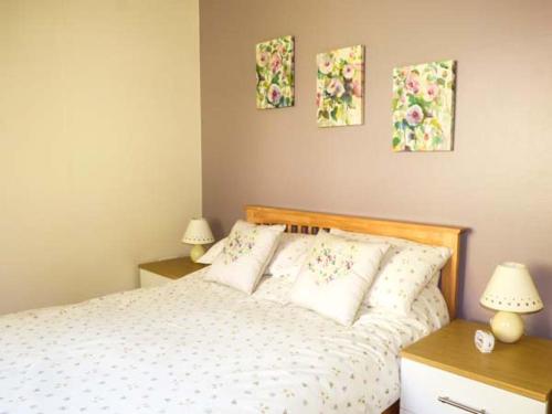 a bedroom with a bed with three paintings on the wall at North Lodge in Staveley