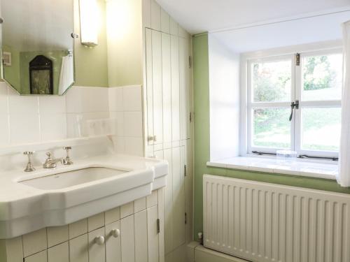 baño con lavabo y ventana en Beulah Cottage en Cinderford