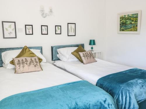 dos camas sentadas una al lado de la otra en un dormitorio en Beulah Cottage en Cinderford