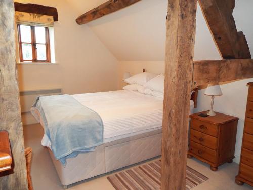 a bedroom with a bed with a wooden bed frame at The Granary in Ross on Wye
