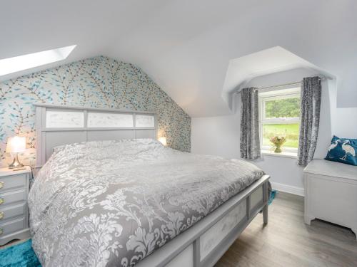 a bedroom with a large bed and a window at Rose Cottage in Alnwick