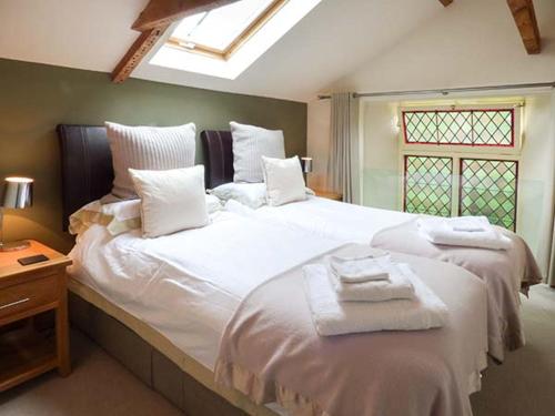 a bedroom with a large white bed with towels on it at The Old Chapel in Malton