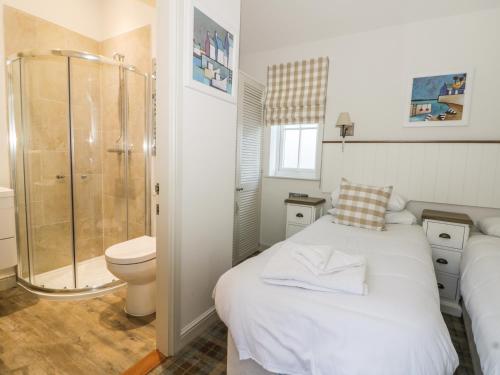 a bathroom with a bed and a shower and a toilet at Sea Dog in Filey