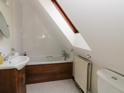 a bathroom with a sink and a bath tub at The Lodge off High Street in Hadleigh