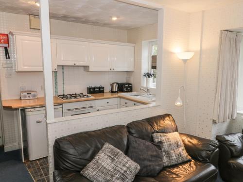 een woonkamer met een bank en een keuken bij Quarterdeck in Scarborough