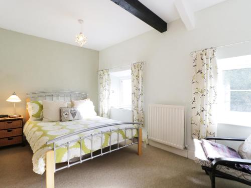 Schlafzimmer mit einem Bett und einem Fenster in der Unterkunft Nightingale Cottage in Threlkeld