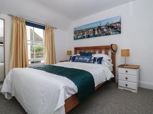 een slaapkamer met een groot bed en een raam bij Westcliff in Penzance