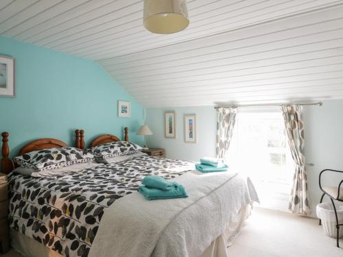 a bedroom with a bed with two towels on it at Daisy Cottage in Perranporth