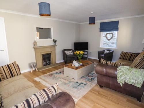 a living room with two couches and a fireplace at Oakdene in Milford Haven