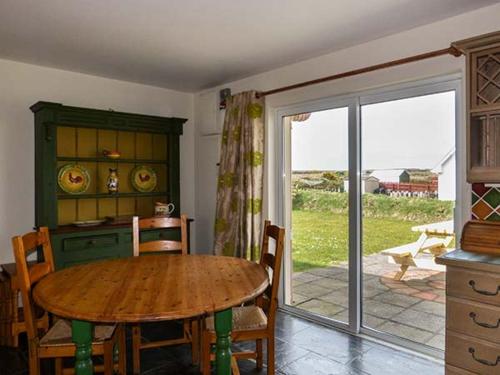 a dining room with a table and a sliding glass door at Bonnie Doon in Kilfearagh