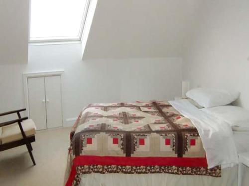 a bedroom with a bed with a quilt on it at The Beach House Apartment in Buncrana