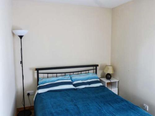 a bedroom with a blue bed with two blue and white pillows at Ti Sheamuis in Clifden