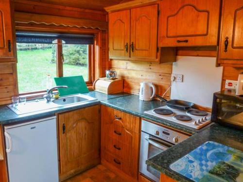 a kitchen with wooden cabinets and a stove top oven at Cabin 2 in Glen