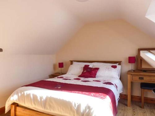 a bedroom with a bed with red pillows on it at The Well House in Kinvara