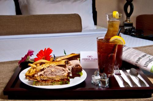 uma bandeja com uma sanduíche e uma bebida na cama em Crowne Plaza Hotel Portland-Downtown Convention Center, an IHG Hotel em Portland