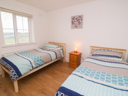 a bedroom with two beds and a window at 63 Moinin in Kilkee