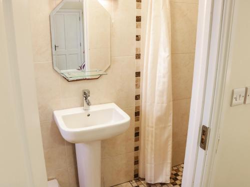 W łazience znajduje się umywalka i lustro. w obiekcie Cloonkee Cottage w mieście Crossmolina
