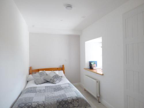 a white bedroom with a bed and a window at 80 New Street in Lismore