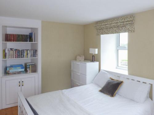 um quarto com uma cama branca e uma janela em Sanderling Lodge em Greenfield Cross Roads