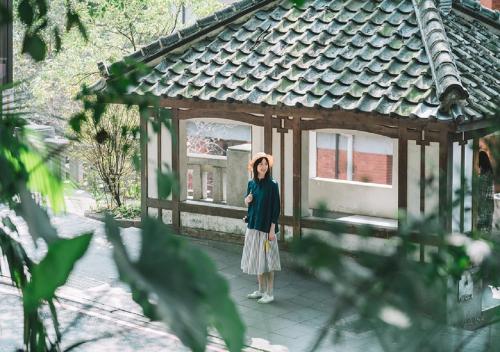 a woman standing in front of a building at Hotel Royal Beitou in Taipei