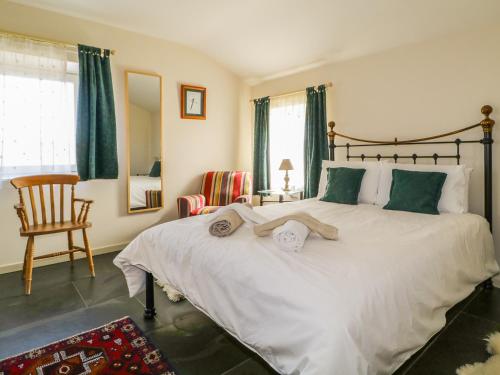 a bedroom with a large white bed and a chair at Buttermere in Cockermouth