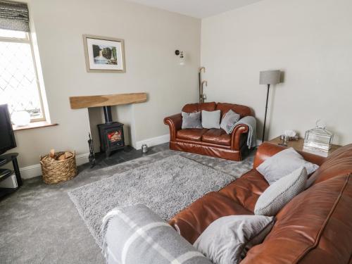 a living room with a couch and a fire place at East Crossthwaite Cottage in Newbiggin