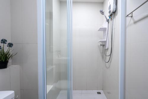 a shower with a glass door in a bathroom at The Base Pattaya by Nami in Pattaya Central