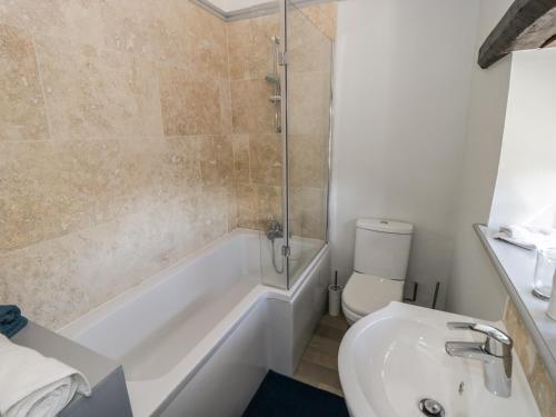 a bathroom with a tub and a toilet and a sink at Edmunds Cottage in Bedale