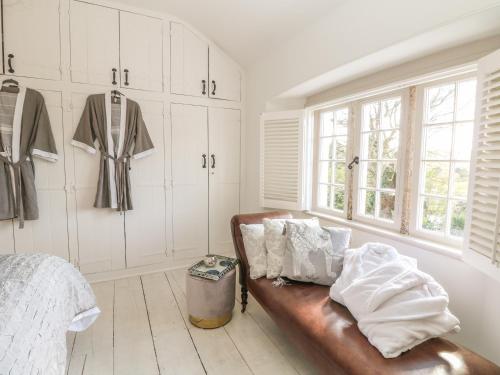 a room with a leather couch in a bedroom at Sea Cliff Cottage in Pentewan