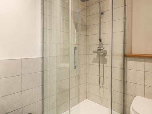 a shower with a glass door in a bathroom at Higher Kernick Farm in Launceston