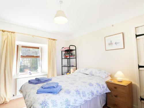 Un dormitorio con una cama con toallas azules. en St Magnus Haven, en Pennan