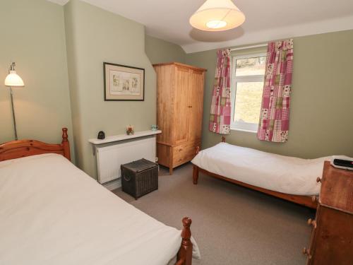 a bedroom with two beds and a window at Valley View Cottage in Foxt