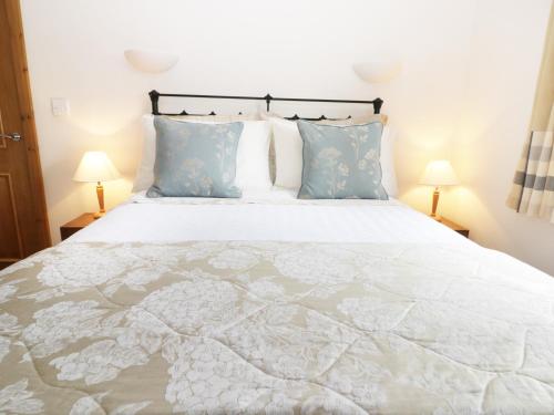 1 dormitorio con 1 cama blanca grande con almohadas azules en Stone Cross, en Lastingham