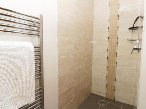 a bathroom with a shower with a glass door at Stone Cross in Lastingham