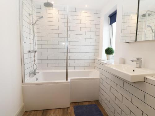 uma casa de banho branca com uma banheira e um lavatório em 21 Llwyn Gwalch Estate em Pwllheli