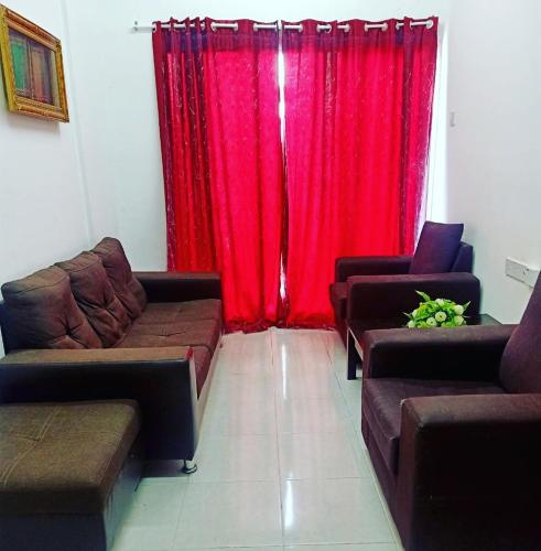 a living room with couches and a red curtain at Homestay Musafir Apartment Seri Iskandar 2.0 in Seri Iskandar