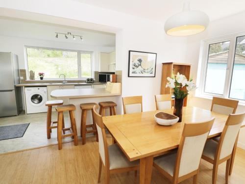 a kitchen and dining room with a wooden table and chairs at Merrydown in Harlech