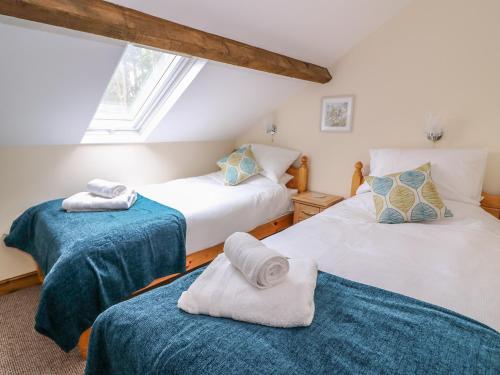 two beds with towels on them in a room at Pentre Fach in Llanddewi Ystradenny