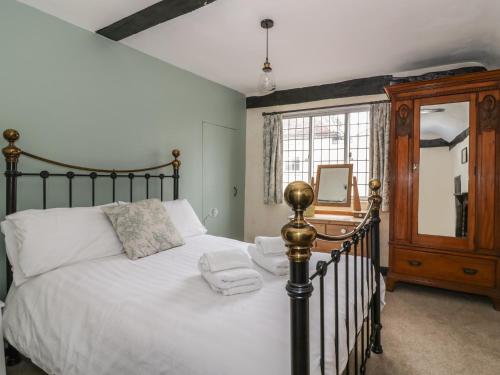 a bedroom with a bed with white sheets and a mirror at Friars Retreat in Sudbury