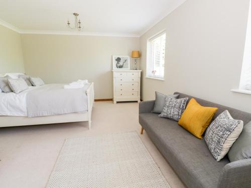 a living room with a couch and a bed at Orchard Cottage in Holywell