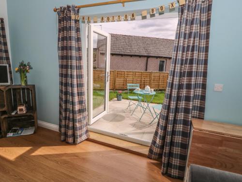 a living room with a sliding glass door with a patio at The Button Box in Huddersfield