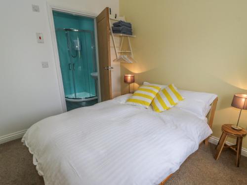 a bedroom with a large white bed with two yellow pillows at The Button Box in Huddersfield