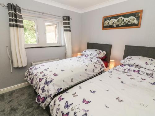 1 dormitorio con 2 camas y ventana en Croft Cottage, en Long Preston