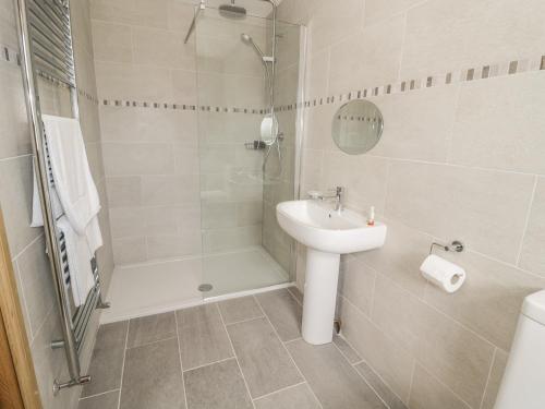 a bathroom with a sink and a shower and a toilet at Rede River Cottage in Corsenside