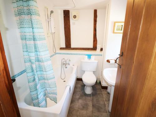 Un baño con bañera, inodoro y lavabo. en Little Duxmore Barn, en Ryde
