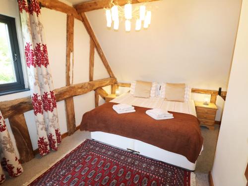 1 dormitorio con 1 cama con alfombra roja en Little Duxmore Barn, en Ryde