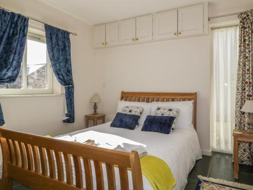 a bedroom with a large bed with blue curtains at Esthers Barn in Cockermouth