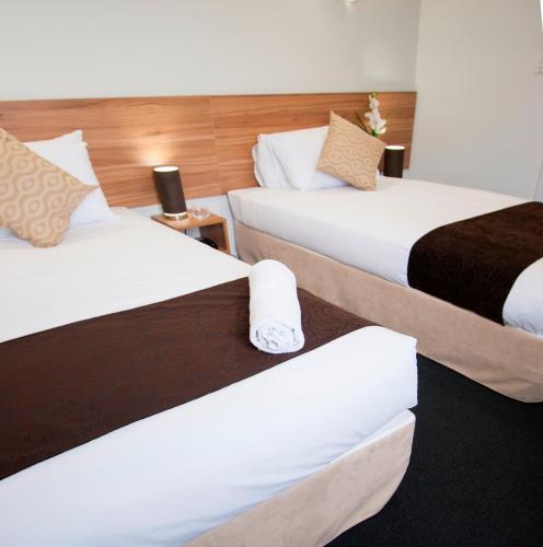 two beds in a hotel room with two bedsskirts at Ascotia Off Queen in Auckland